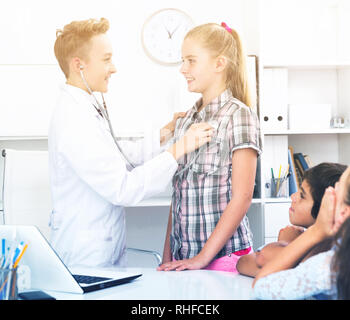 Giovane maschio medico in uniforme medica leader appuntamento con i bambini Foto Stock