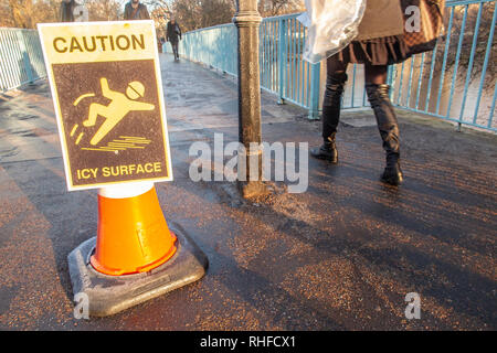 Un avvertimento su ghiaccio scivoloso su un ponte di St James Park, Londra in inverno Foto Stock