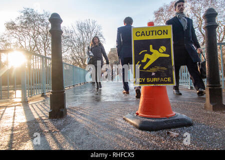 Un avvertimento su ghiaccio scivoloso su un ponte di St James Park, Londra in inverno Foto Stock