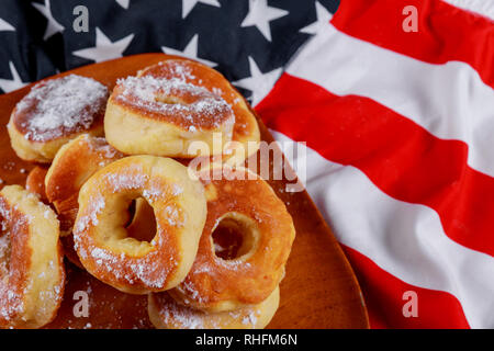 Ciambella con zucchero a velo e bandiera americana sul piatto di legno, American Independence Day, celebrazione, il patriottismo e il concetto di vacanze Foto Stock