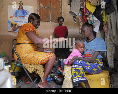 KENYA Mombasa, la baraccopoli del Bangladesh. Caroline Osong, assistente sociale dal Bangladesh clinic visitando i pazienti nelle loro case. Qui con Caroline Wanza chi è sieropositivo e sua figlia Juliana, 15, baby e Maria. Foto Stock