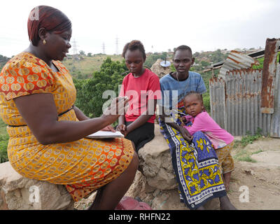 KENYA Mombasa, la baraccopoli del Bangladesh. Caroline Osong, assistente sociale dal Bangladesh clinic visitando i pazienti nelle loro case. Qui con Caroline Wanza chi è sieropositivo e sua figlia Juliana, 15, baby e Maria. Foto Stock