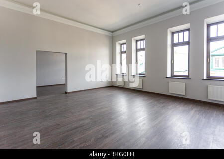 Vista laterale della camera non ammobiliata loft interno con pavimento in legno, pareti di colore bianco con brillante luce diurna Foto Stock