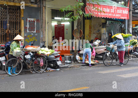 Hanoi, Vietnam - 13 dicembre 2017. Venditori ambulanti vendono frutta, ortaggi e fiori da loro bici nella storica vecchia di Hanoi Foto Stock