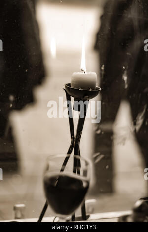 Immagine in bianco e nero di una candela e un bicchiere di vino presso il ristorante in finestra Foto Stock