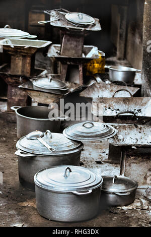 Gruppo di carbone di legna rustico stufe e pentole, padelle e casseruole sul pavimento al mercato locale di Toliara, Madagascar. Foto Stock