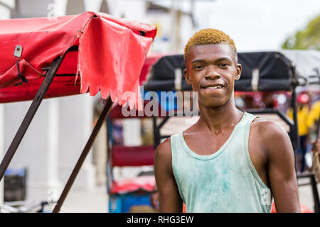 Toliara, Madagascat - Gennaio 10th, 2019: Ritratto di una giovane uomo malgascio chi è un pousse pousse driver con i suoi capelli tinti di colore arancione in Toliara, M Foto Stock