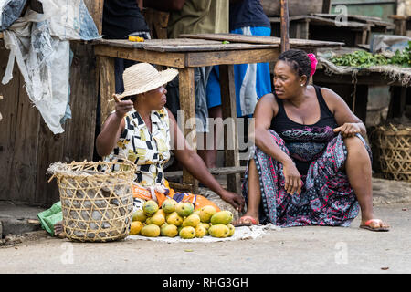 Toliara, Madagascar - Gennaio 10th, 2019: due donne malgasce ambulanti discutendo seduti sul marciapiede presso il locale mercato alimentare di Toliara, Ma Foto Stock