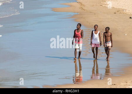 Durban, Sud Africa - Gennaio 7th, 2019: Tre South African uomini neri camminare da solo in spiaggia guardando il mare in una spiaggia a Durban, Sud afri Foto Stock