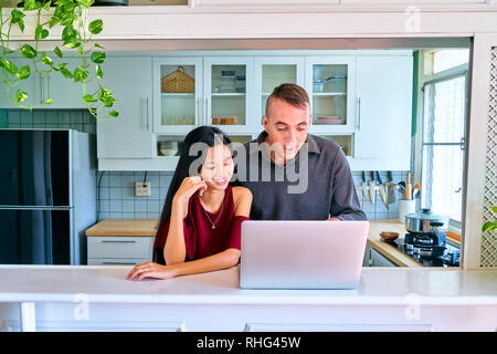 Coppia adorabile che pongono - guardare i film sul computer portatile e godendo Foto Stock
