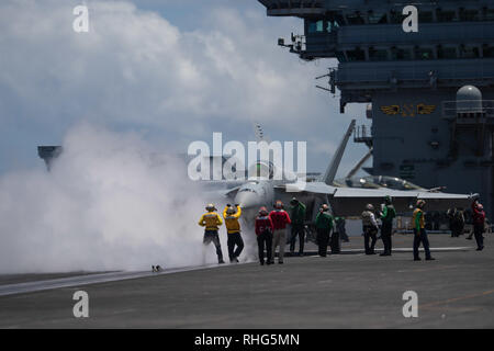 Stati Uniti I marinai dirigere un'F/A-18E Super Hornet, assegnato a Strike Fighter Squadron (VFA) 97, verso un vapore-powered catapulta sul ponte di volo della portaerei USS John C. Stennis CVN (74) nell'Oceano Indiano, 1 febbraio 2019. John C. Stennis è distribuito negli Stati Uniti 7 flotta area di operazioni a sostegno della sicurezza e della stabilità nella regione Indo-Pacifico. (U.S. Foto di Marina di Massa lo specialista di comunicazione di terza classe concedere G. Grady) Foto Stock