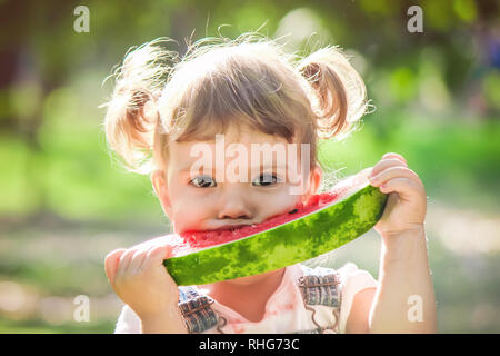 Un bambino mangia anguria. Messa a fuoco selettiva. Foto Stock