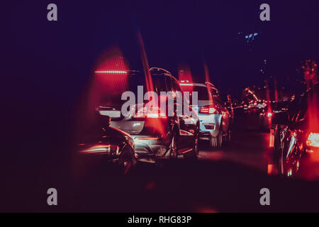 Vetture nella notte traffico . Guardando dietro le vetture.Auto sono di colore rosso, giallo luce da notte. Gli inceppamenti di traffico nella città con fila di vetture su strada a Foto Stock