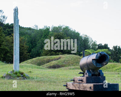 Pou whenua intagliata in legno post e rotto il cannone, tumuli e incavi rimane di fortificazione dei terrapieni, Ruapekpeka, Northland e Nuova Zelanda Foto Stock