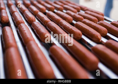 Diversi hot dog che cucinano su una macchina a rulli Foto Stock