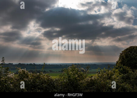Paesaggio in West Sussex, Regno Unito con il sun streaming attraverso le nuvole Foto Stock