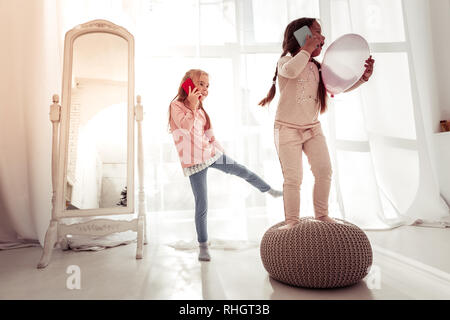 Gioioso ragazze positiva con i loro nuovi smartphone Foto Stock