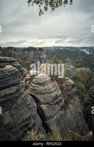 Densa nebbia sulle montagne dal punto di vista di Bastei nella Svizzera sassone, Germania alle montagne di sunrise nella nebbia mattutina, il parco nazionale di Saxon SVIZZ Foto Stock