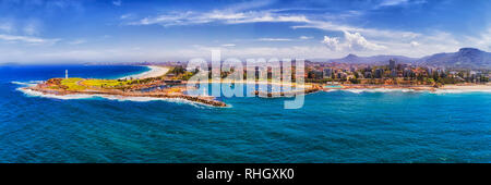 Città costiera di Wollongong su Australian NSW Costa Sud visto dal mare aperto verso il lungomare con le case e le strade intorno al promontorio, fari e h Foto Stock