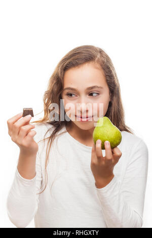 Ragazza giovane scegliendo tra frutta e cioccolata isolati su sfondo bianco Foto Stock