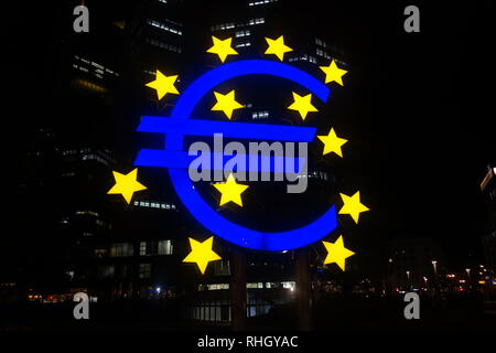 Illuminated Euro segno scultura di notte al di fuori della Eurotower building di Francoforte am Main. Foto Stock