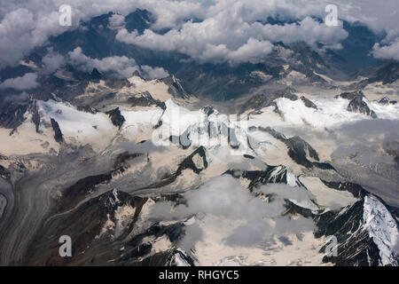 Il top della gamma della montagna, tra le nuvole sono visibili le cime e le pendici delle montagne coperte di neve, l'Himalaya. Foto Stock