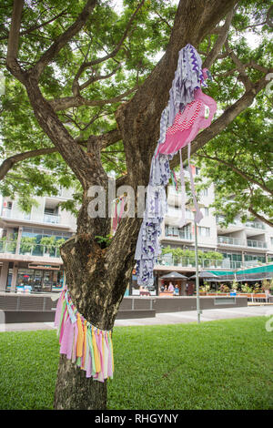 Darwin, Northern Territory, Australia-October 27,2017: Tessuto arte di installazione su un trunk ​tree presso il lungomare con i turisti a Darwin, in Australia Foto Stock