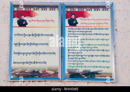 Il Tibetano-lingua messaggio di propaganda da Presidente Xi Jinping pubblicato su una parete in corrispondenza del monastero Ganden, al di fuori di Lhasa, in Tibet, Cina Foto Stock