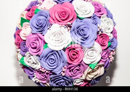 Un close-up di un romantico artificiale di bouquet di fiori di un lilla, rosa e bianco tessuto realizzato da foamiran su uno sfondo vuoto è un regalo per il lon Foto Stock