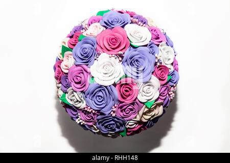Un close-up di un romantico artificiale di bouquet di fiori di un lilla, rosa e bianco tessuto realizzato da foamiran su uno sfondo vuoto è un regalo per il lon Foto Stock