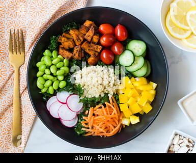 Vista aerea di sana insalata di cavolo ciotola con verdure - patate dolci, pomodori, cetrioli, peperoni, carota, ravanello e edamame con la quinoa. Foto Stock