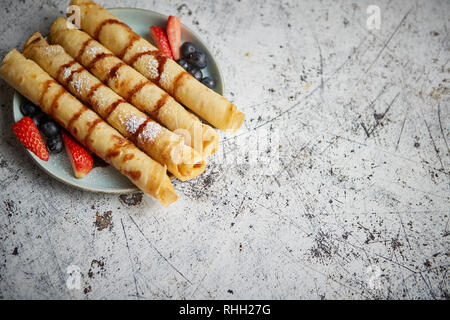 Piatto di deliziosa crepes rotolo con frutta fresca e cioccolato Foto Stock