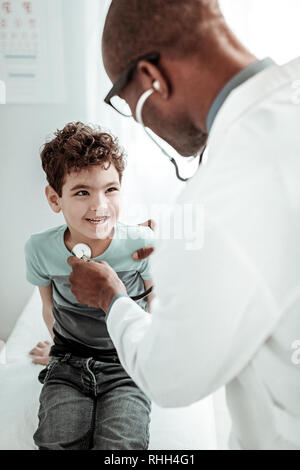 Attento kid comunicante con il suo medico di famiglia Foto Stock