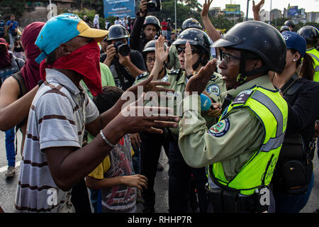 Caracas, Venezuela. 02Feb, 2019. Persone mascherate discutere con poliziotti. Più di un centinaio di migliaia di venezuelani sono stimati a hanno dimostrato di Caracas per auto-proclamato presidente ad interim Juan Guaidó. Credito: Rayneri Peña R/dpa/Alamy Live News Foto Stock