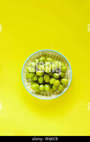 Mosti di uve fresche su sfondo giallo laici piatta Foto Stock