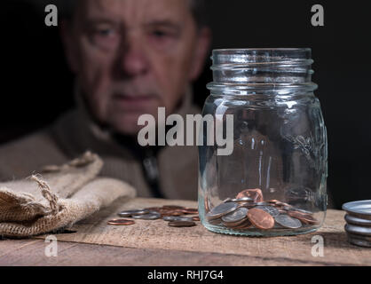 Senior pensionati uomo caucasico guardando il resto dei risparmi Foto Stock