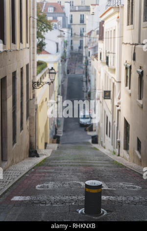 Strada lunga e stretta in chiado Lisbona, Portogallo. Elevazione, rampa, collina andando su e giù. Pendenza con forte inclinazione. Arrestare scritto sulla strada. Foto Stock