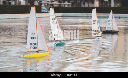 Piccola Vela barche giocattolo di gara. Mini remote di Stagno controllato le barche a vela e yacht in una piccola città sul lago. Foto Stock