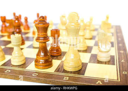 Pezzi di scacchi permanente sulla scacchiera isolati su sfondo bianco Foto Stock