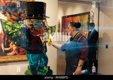 Un pulitore lucidi un pezzo di arte il lavoro in galleria a Londra, swanky Mayfair Foto Stock