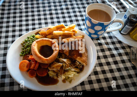 Placcato bistecca caldo Torta a base di carne con patatine e salsa pasto britannico su una plastica gingham tabella panno in una caffetteria di Doncaster, nello Yorkshire, Inghilterra Foto Stock