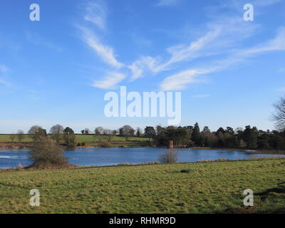 Big Blue Skies & wispy bianco delle nuvole sopra il serbatoio a Sywell Country Park; una scena invernale nel Northamptonshire Foto Stock