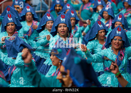 Llamerada ballerini in costumi ornati di eseguire come sfilano attraverso la città mineraria di Oruro sull'altipiano della Bolivia durante il carnevale annuale Foto Stock