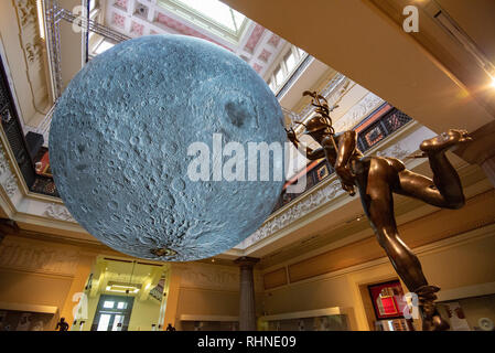 Preston, Regno Unito. 03Feb, 2019. I battenti statua di Mercurio sembra salutare il Museo della luna, un artwork da Luke Jerram, all'Harris Museo e Galleria d'arte, Preston, Lancashire. I sette metri di diametro sfera sarà in tournée in varie mostre e festival in tutto il mondo. Credito: John Eveson/Alamy Live News Foto Stock