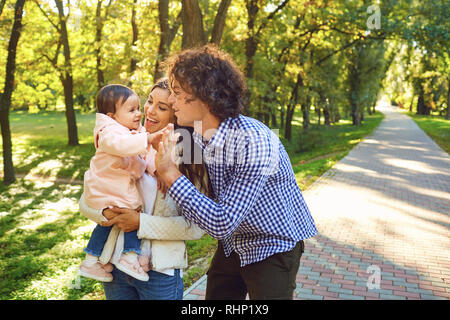 La famiglia felice in piedi a giocare nel parco. Foto Stock