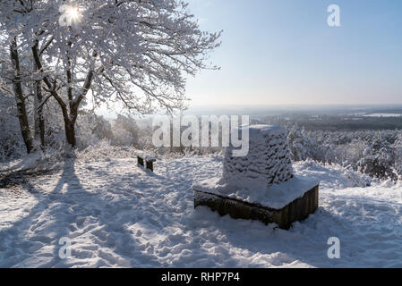 Bella scena di neve al punto Trig sulla collina Crooksbury, Farnham con il sole che splende attraverso la struttura ad albero Foto Stock