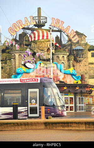 Bombardier tram gestiti da Blackpool trasporti passa di fronte all isola di corallo sala giochi sul lungomare Foto Stock