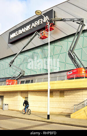 Lavoratori in Cielo il martinetto di paranchi di sollevamento Pulizia della parte anteriore del M&S Bank Arena (precedentemente il Liverpool Echo Arena) su King's Dock, Merseyside Foto Stock