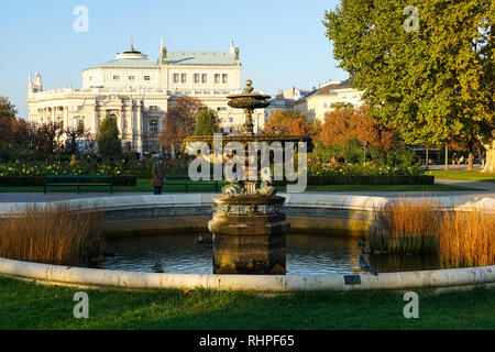 Fontana nel parco Volksgarten e giardino e Burgtheater (austriaco Teatro nazionale), Vienna, Austria Foto Stock