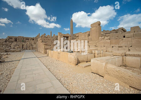 Outodoor cortile e il grande muro di pietra al tempio di Karnak cortile in Luxor Egitto con obelisco e cielo blu sullo sfondo Foto Stock